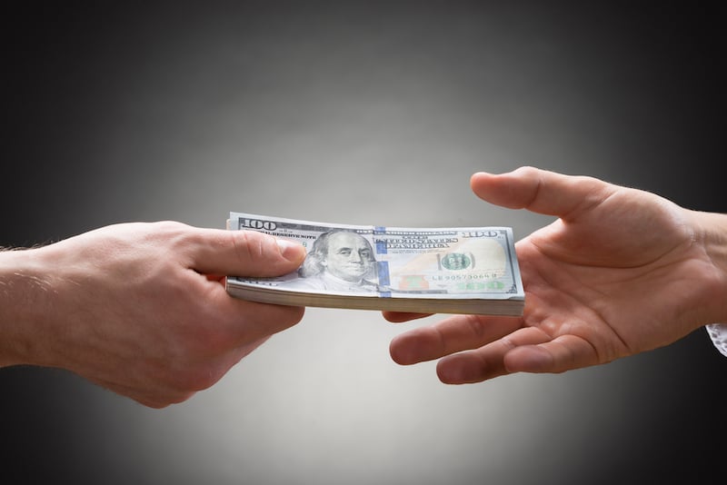 Close-up Of Person Hand Giving Money To Other Hand